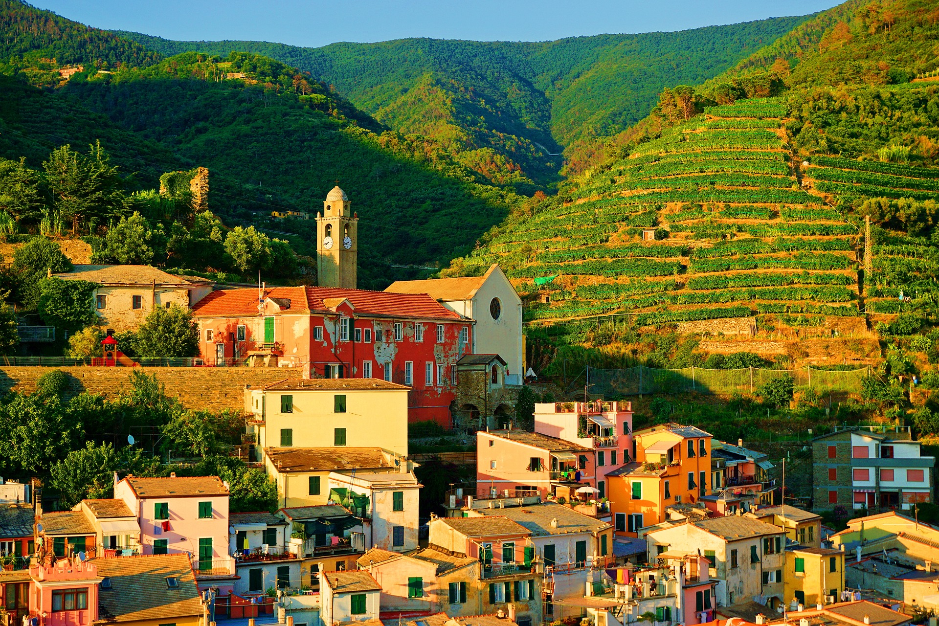 Die bunten Häuser der ligurischen Ortschaft Vernazza im Nationalpark Cinque Terre und die dortigen Berge und landwirtschaftlich genutzten Hänge