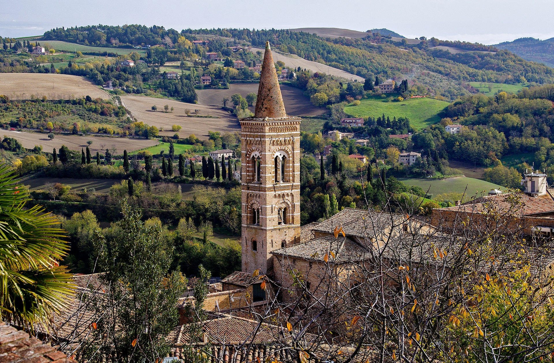 Glockenturm in Urbino vor malerischer Landschaft