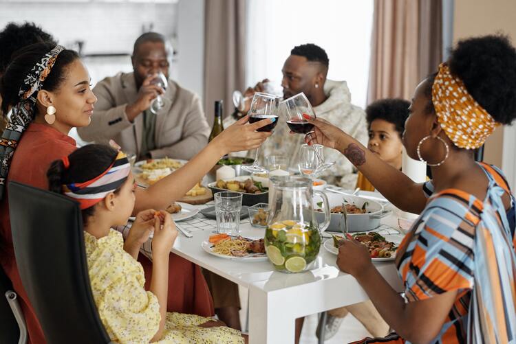 Familie ist zu Ostern von einem reichlich gedeckten Tisch und stößt mit Wein an