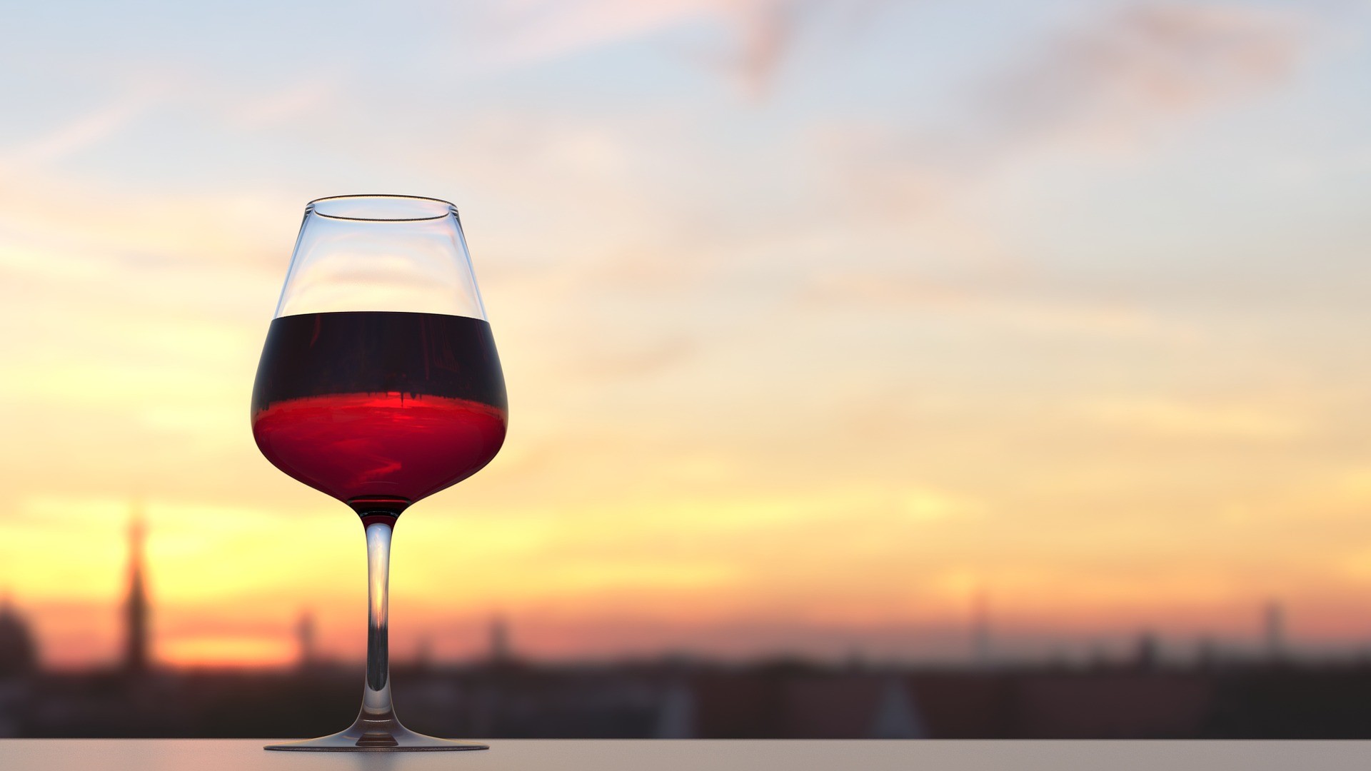 Rotweinglas, in dem sich die Silhouette einer Stadt Spiegel, vor Abendhimmel