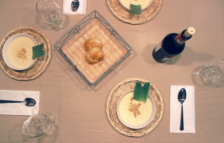 Cremesuppen und Rotwein auf einem gedeckten Tisch von oben