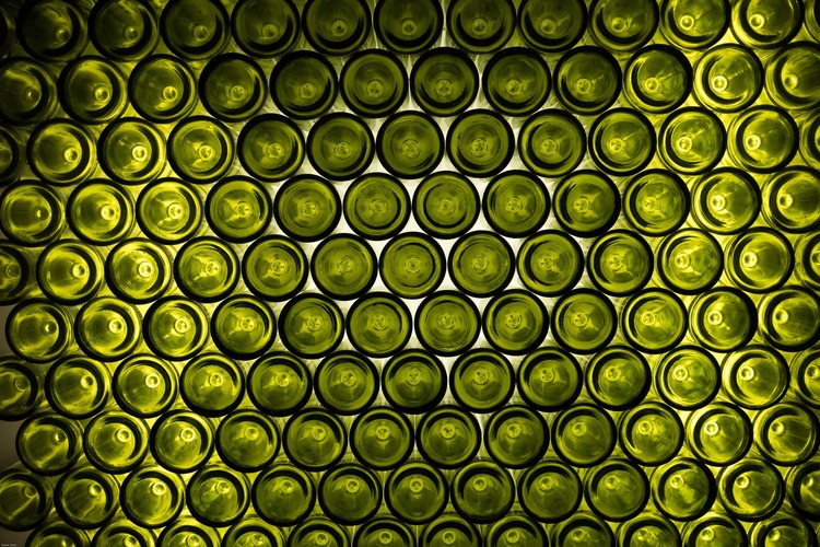 Viele grüne Flaschenböden aufeinandergestapelter Weinflaschen
