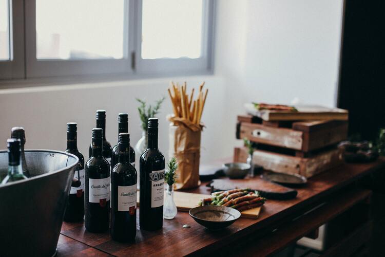 Klassisch italienische Grissini stehen neben Weinflaschen auf einem Tisch