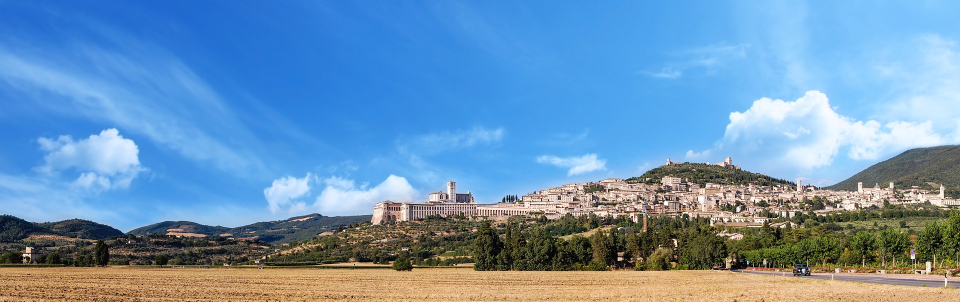 Die umbrische Stadt Assisi aus einiger Entfernung und unter strahlend blauem Himmel
