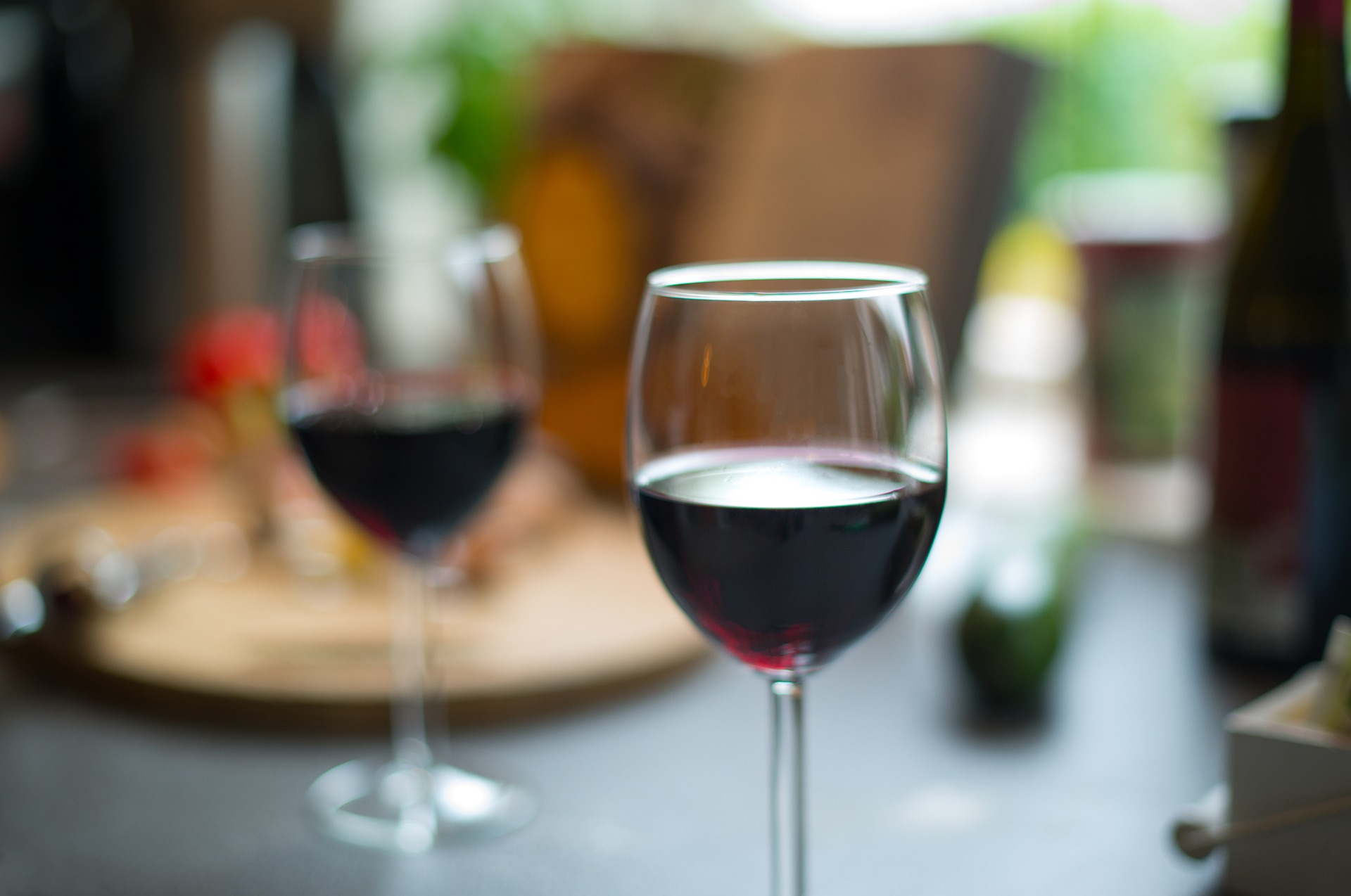 Zwei halbvolle Rotweingläser auf einem gedeckten Tisch