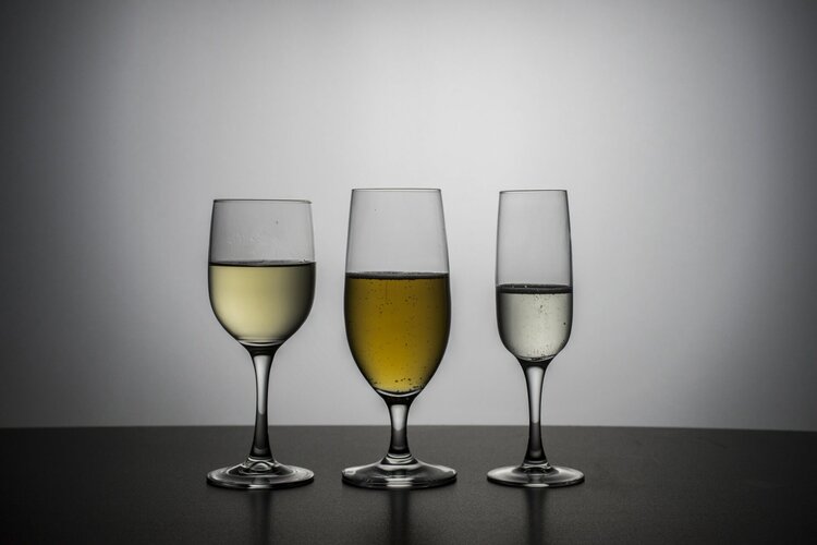 Ein Wein-, ein Bier- und ein Sektglas nebeneinander aufgereiht