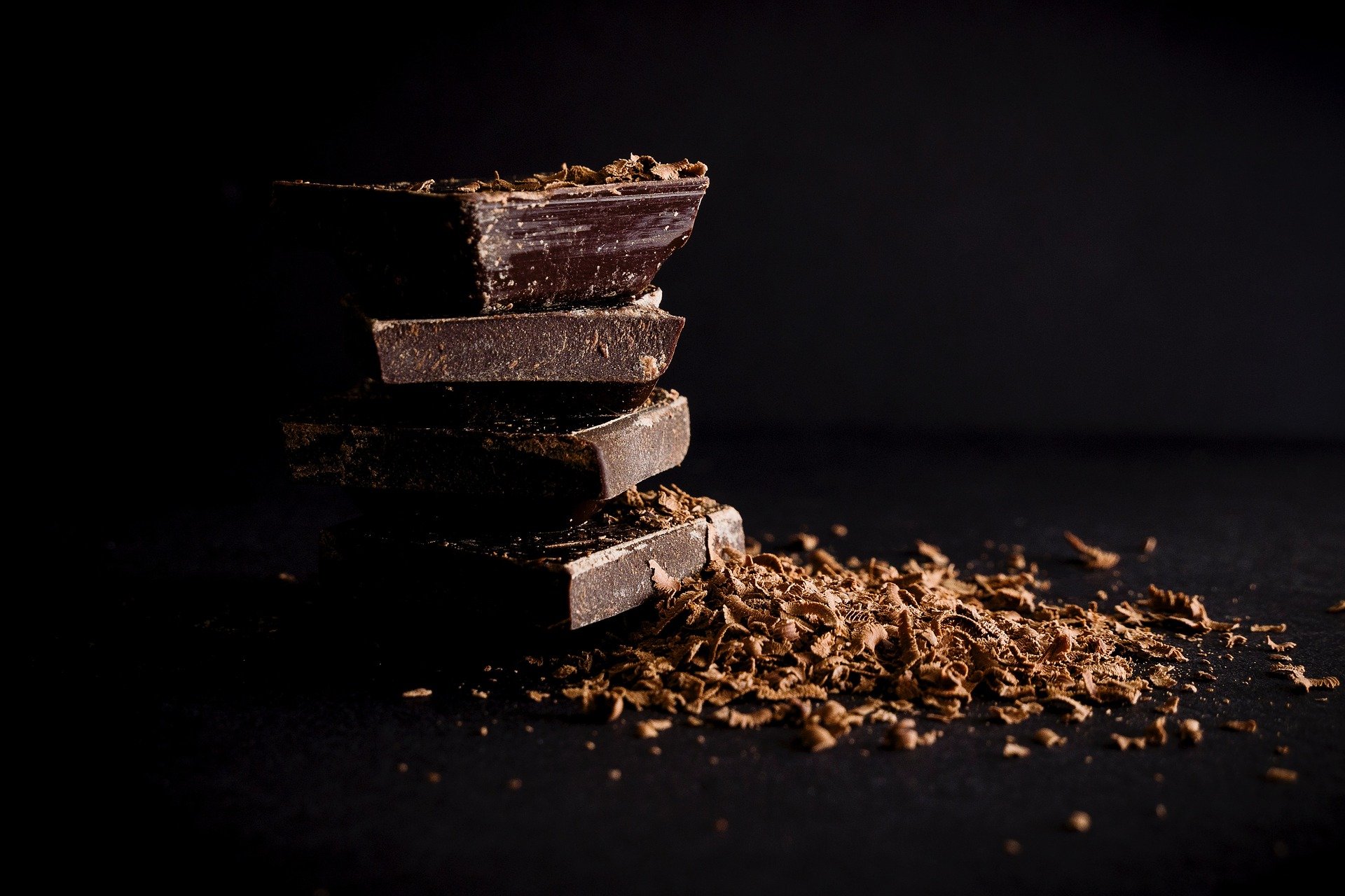 Gestapelte Schokoladenstücke vor schwarzem Hintergund